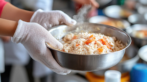 Person wearing gloves and wearing a bowl of food